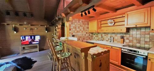 a kitchen with a counter and a tv in the background at AlpinResort DerBacherhof in Niedernsill