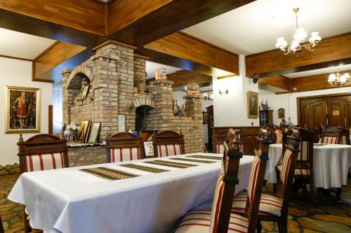a dining room with a table and a stone fireplace at Casa Baciu in Fundu Moldovei