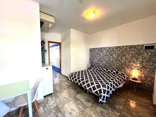 a bedroom with a black and white bed and a table at Residence Frontemare in Rimini