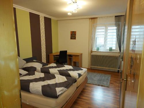 a bedroom with a bed and a desk and a window at MariazellKernboden in Gusswerk