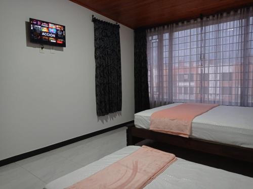 1 dormitorio con 2 camas y ventana en New comfortable house at Paipa close to everything great location, en Paipa
