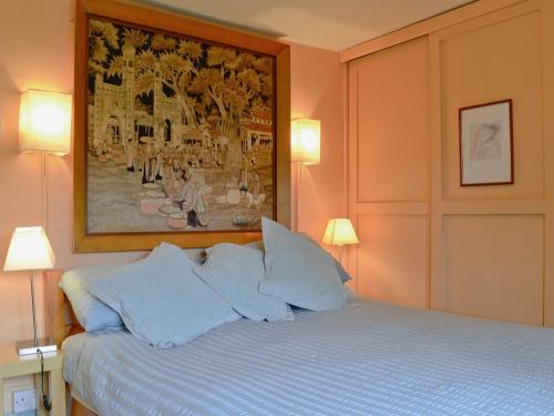 a bedroom with a bed with a painting on the wall at Sherwell Court in Buckfastleigh