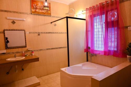 La salle de bains est pourvue d'une baignoire, de toilettes et d'un lavabo. dans l'établissement Hotel Wild Rose, à New Delhi