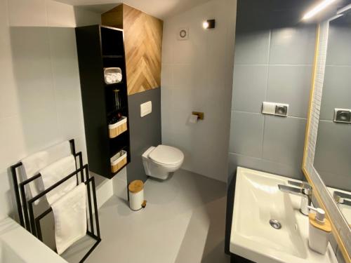 a bathroom with a white toilet and a sink at Yose Apartment - 160 m2 na wyłączność in Poznań
