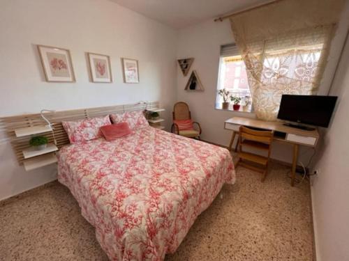 Apartamento ideal familias في Playa de Gandia: غرفة نوم بسرير ومكتب وجهاز كمبيوتر