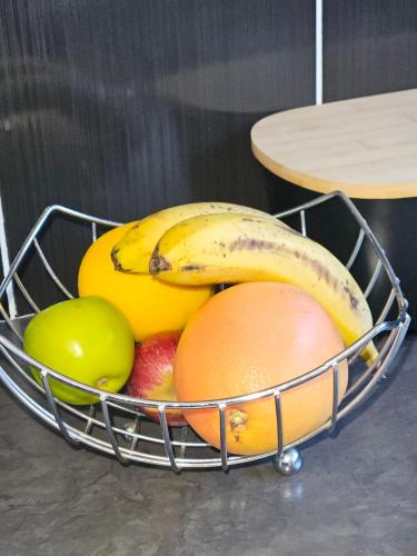 a basket of fruit with bananas oranges and apples at Three Stones Executive Apartments in Maseru