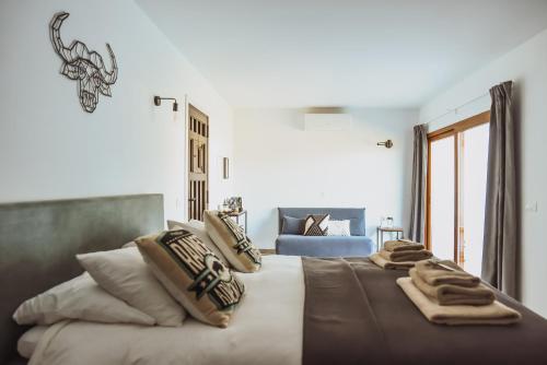ein Schlafzimmer mit einem großen Bett mit Decken und Kissen in der Unterkunft Finca Viva la Vida in Alora