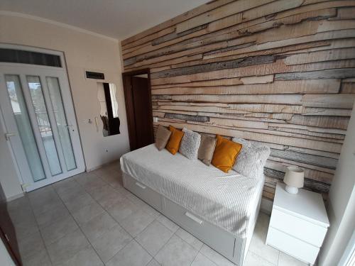 a bedroom with a wooden accent wall and a bed at Wellness Apartman in Siófok