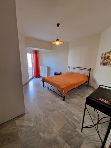 a bedroom with an orange bed and a table at Maria's Sharing Apartment in Heraklio