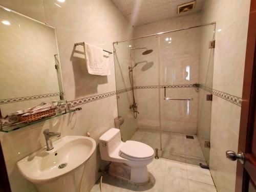 y baño con ducha, aseo y lavamanos. en Quoc Dung Hotel, en Rạch Giá