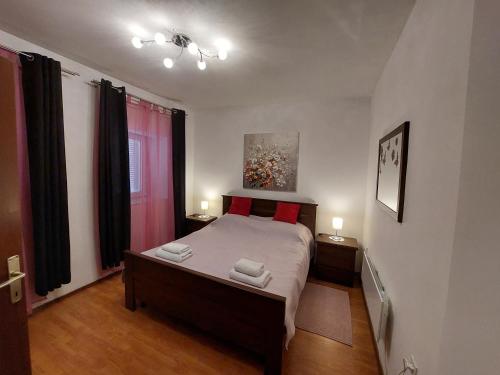 a bedroom with a bed with two towels on it at Apartman Rozmari in Lokve