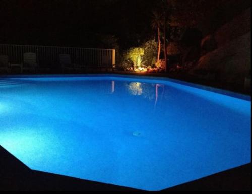 una gran piscina azul iluminada por la noche en Résidence de luxe Sun Paradis, Studio terrasse, vue Mer Piscine en Cannes