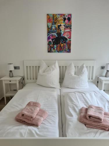 2 serviettes assises au-dessus d'un lit blanc dans l'établissement Constanza, à Plau am See
