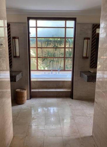 a large bathroom with a large window and a tub at Jimbaran BeachStroll Villa (3BR) in Jimbaran