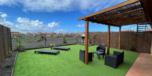 a patio with benches and a pergola at Villa Twins in Lajares