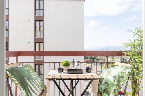 uma varanda com uma mesa e plantas sobre ela em Aeroporto - Modern Apartment em Florença