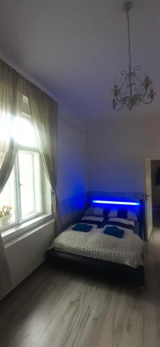 een slaapkamer met een bed met blauwe verlichting bij Apartmán Matty v tichom dvore priamo v centre in Bratislava