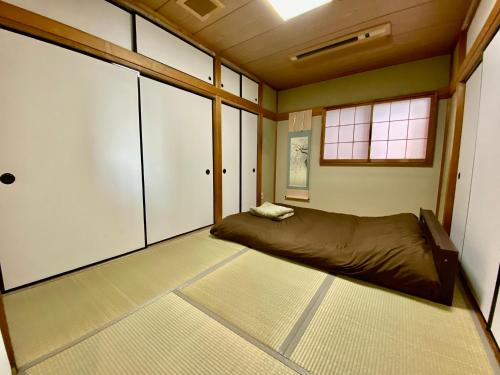 una camera da letto con un letto nell'angolo di una stanza di Hotel EL 8（宇都宮駅東口） a Utsunomiya