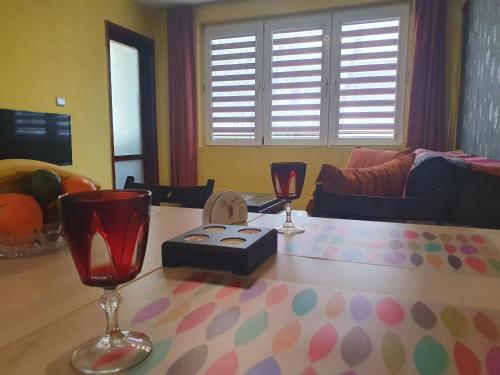 ein Wohnzimmer mit einem Tisch und 2 Weingläsern in der Unterkunft Eli Apartment in Burgas City