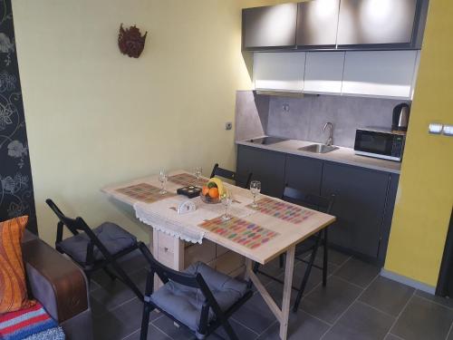 a kitchen with a table with chairs and a sink at Eli Apartment in Burgas