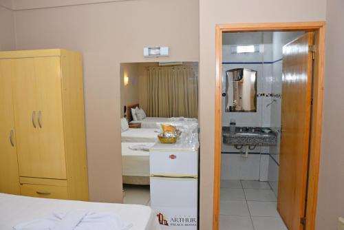 Habitación con cama y baño con lavabo. en Arthur Palace Hotel, en Encarnación