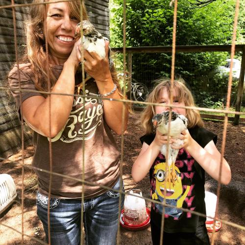 a woman and a little girl holding chicken in a cage at Laurel River Club Bed & Breakfast or LRCBNB in Dryfork