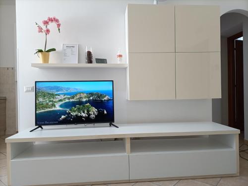 einen TV auf einem weißen Regal im Wohnzimmer in der Unterkunft Appartamenti Doria in Civitavecchia