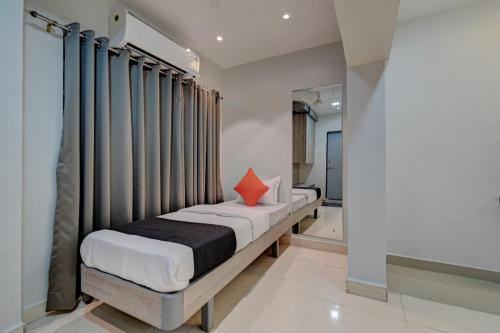 1 dormitorio con 1 cama con almohada roja en Hotel Vikrant, en Pune