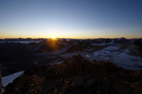a view of the sun setting over the mountains at Ferienwohnung Rimml in Sankt Leonhard im Pitztal