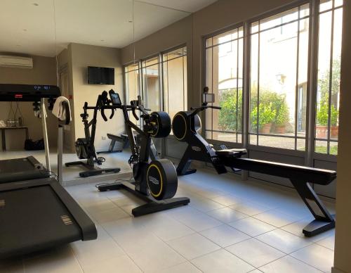 a gym with several treadmills and a treadmill at Les Glycines - Hôtel & Spa - Teritoria in Les Eyzies-de-Tayac