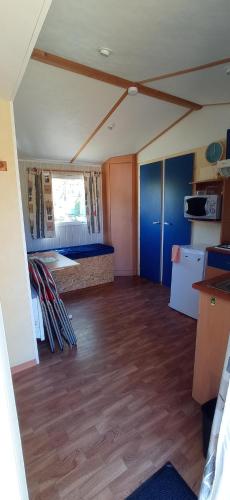 an empty room with wood floors and a room with a table at CAMPING LE BEL AIR- Mobil home le laurier in Limogne-en-Quercy