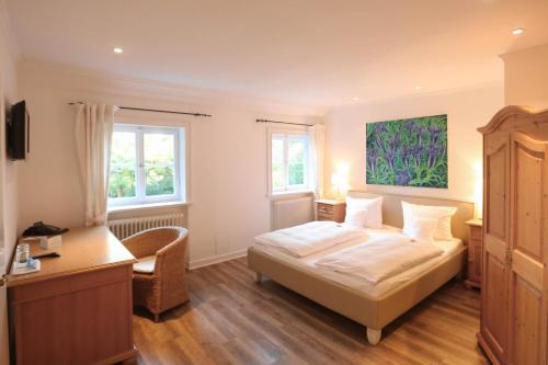 a bedroom with a bed and a desk and windows at Landhaus am See in Garbsen