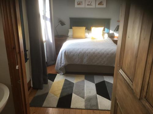 1 dormitorio con 1 cama con alfombra a cuadros en Dromelihy House Stud, en Doonbeg