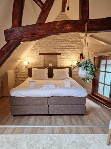 een slaapkamer met een groot bed in een bakstenen muur bij De Hofstee in Maastricht