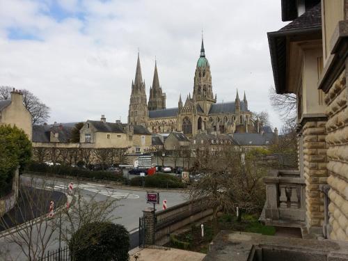 a large building with a clock tower on top of it at Le Castel Guesthouse in Bayeux