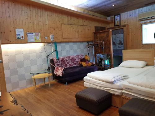 車城郷にあるChecheng Backpackers Hostelのベッド2台、ソファにテディベアが備わります。