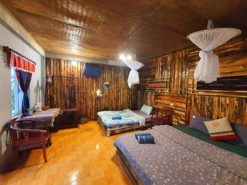 a bedroom with two beds in a room with wooden walls at La Beauté Bắc Hà in Bắc Hà