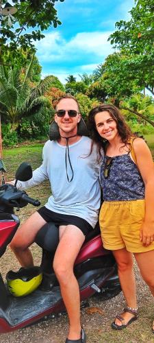 two women and a man sitting on a scooter at House of TamSe Laagans ' Inn in Badian