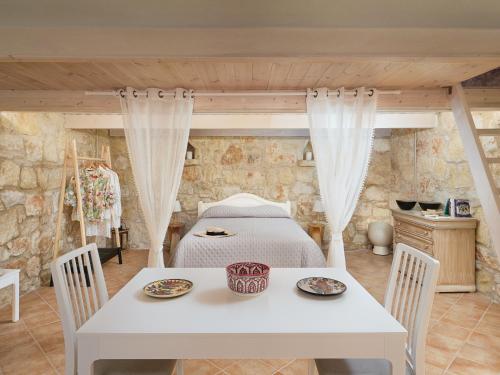 アルカネスにあるThe Olive Grove Cottage with private swimming poolのベッドルーム1室(ベッド1台、テーブル、椅子付)