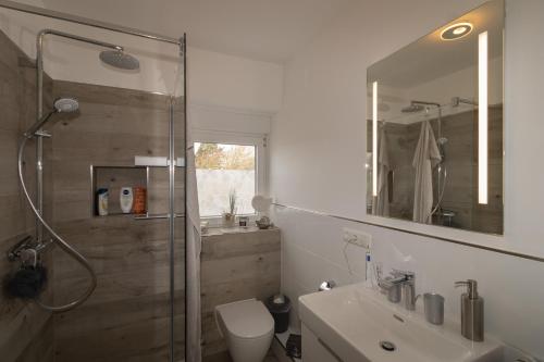 ein Bad mit einer Dusche, einem WC und einem Waschbecken in der Unterkunft Haus Möwe Wohnung Leuchttürmchen in Hörnum
