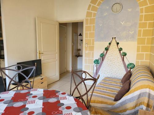 a room with a table and a hammock in a room at Appartement traversant et lumineux avec terrasse in Saint-Laurent-du-Var