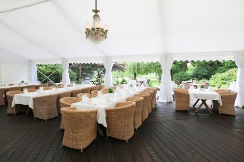 a marquee with white tables and chairs and a chandelier at Landhaus am See in Garbsen