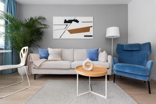 a living room with a couch and two chairs at Apartament Bielany 3 min from metro with 5-meals per day diet catering, air conditioning and free parking in Warsaw