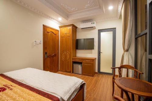 a bedroom with a bed and a table and a television at TRÍ TÂM HOTEL - Khách sạn TRÍ TÂM Bến Lức in Bến Lức