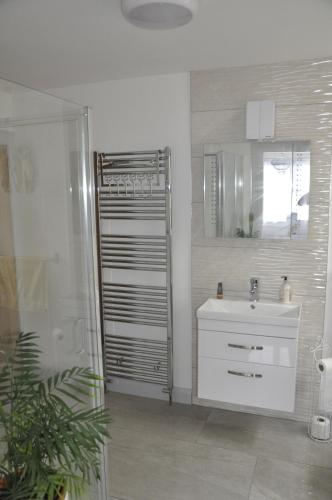 a white bathroom with a sink and a mirror at Hillside Luxury Bed & Breakfast in Ballycastle