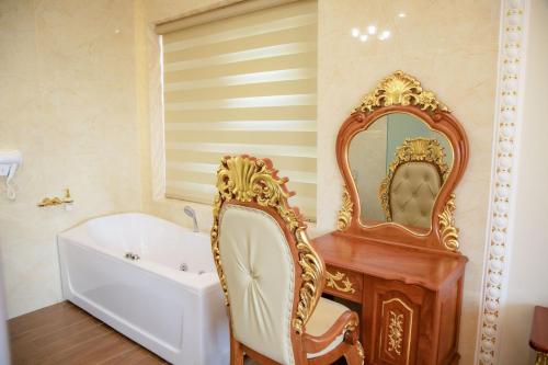 a bathroom with a tub and a mirror at TRÍ TÂM HOTEL - Khách sạn TRÍ TÂM Bến Lức in Bến Lức