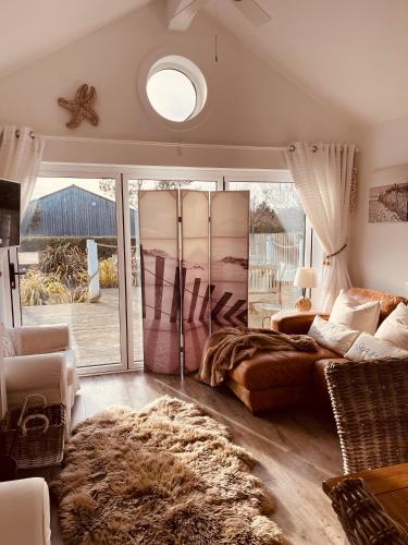 a living room with a bed and a large window at Boardwalk@TheBay, Filey in Filey