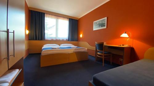 Milín的住宿－Hotel U Milína，酒店客房配有两张床和一张书桌