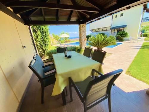 a dining table and chairs on a patio at Villa Oceanview Vicky in Pefkochori