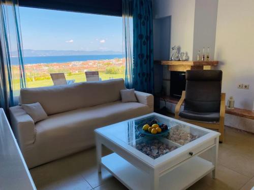 a living room with a couch and a table at Villa Oceanview Vicky in Pefkochori